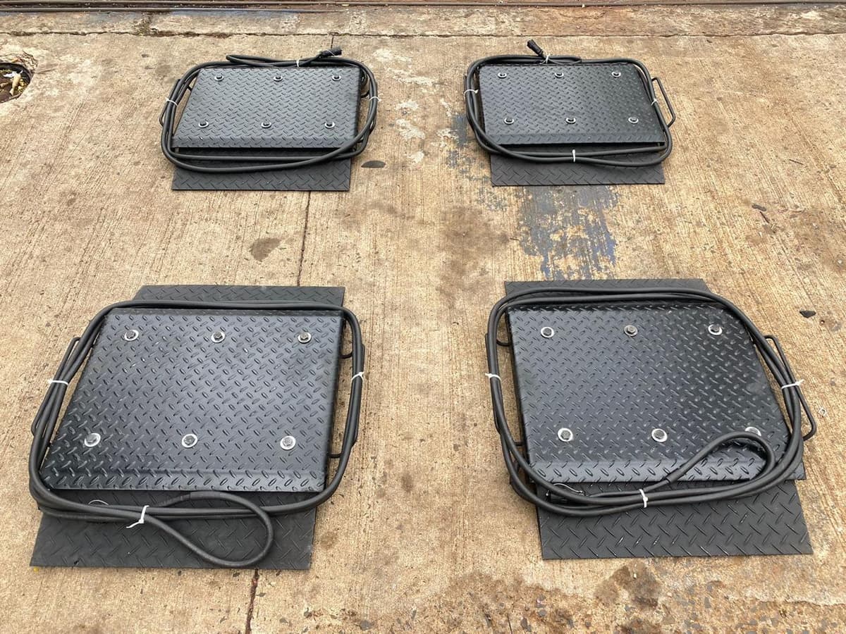 As quatro plataformas da balança de sapata prontas para posicionar, com os cabos de conexão